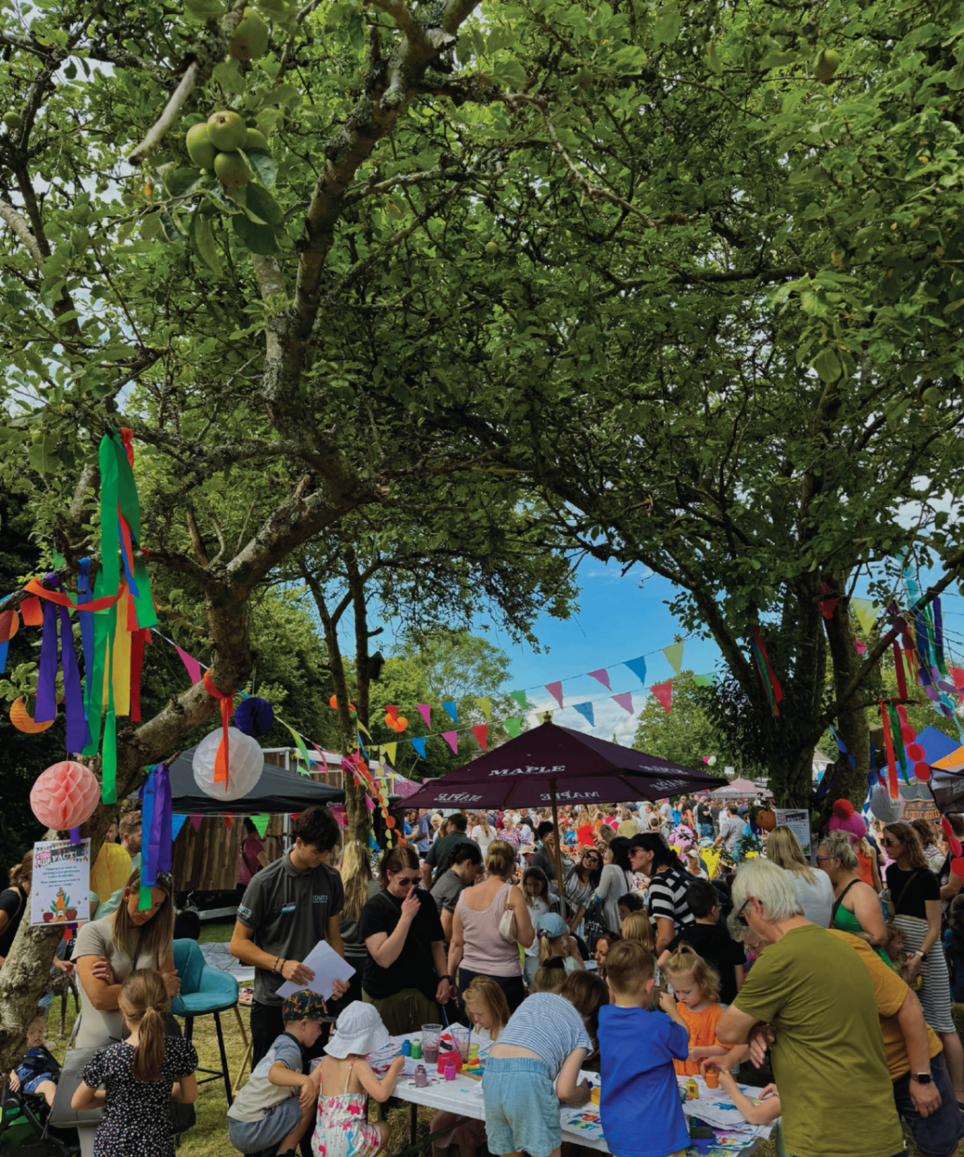 Food Fest visitors under bunting and gazebos on the green